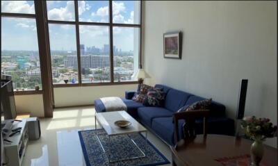 Spacious living room with large windows and city view