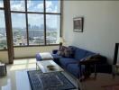 Spacious living room with large windows and city view