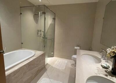 Modern bathroom with tub and glass-enclosed shower.