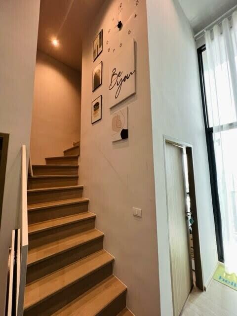 Staircase with modern decor and tall ceiling window