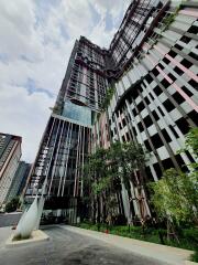 Modern high-rise building exterior with plants and trees