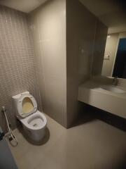 Modern bathroom with tiled walls, toilet, and sink