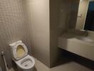 Modern bathroom with tiled walls, toilet, and sink