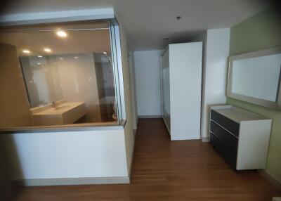 Modern bedroom with wooden flooring and glass partition