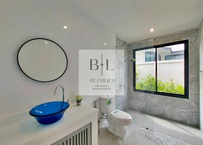 Modern bathroom with a blue sink and large window