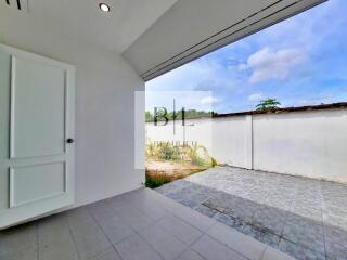 Outdoor space with tiled flooring and white wall