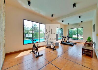 Home fitness room with equipment and pool view