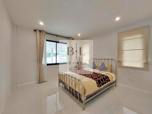 Spacious bedroom with a metal bed frame and natural lighting