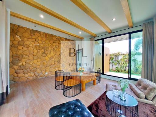 Living room with stone accent wall and large windows