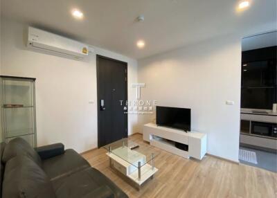 Modern living room with sofa, TV, and glass coffee table