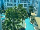 View of complex courtyard with pool and palm trees