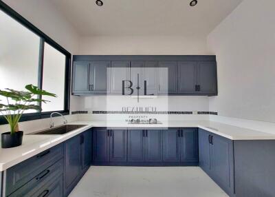 Modern kitchen with dark blue cabinets and large window