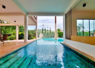 Covered outdoor pool area with tropical garden view