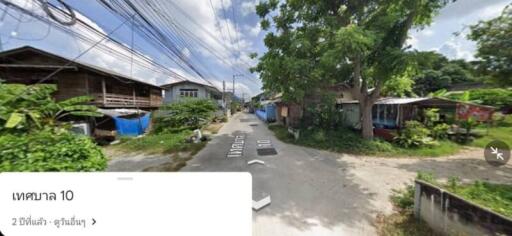 Street view of a neighborhood with houses and greenery