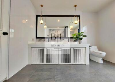 Modern bathroom with large mirror and contemporary lighting