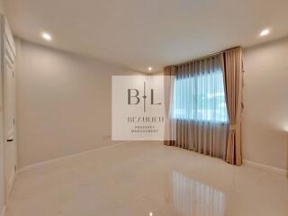 Spacious empty bedroom with large window and curtains