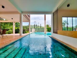 Outdoor pool area with seating and greenery