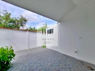 Outdoor patio space with greenery and tiled floor