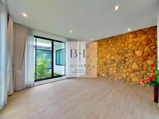 Spacious living room with stone accent wall and large window