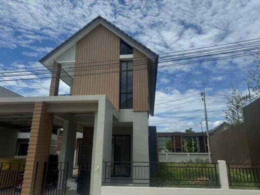 Two-story modern house with large windows and wooden exterior detail