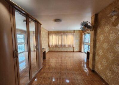 Spacious bedroom with large windows, wooden floors, and built-in wardrobes