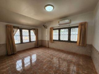 Spacious living room with large windows and tile floor