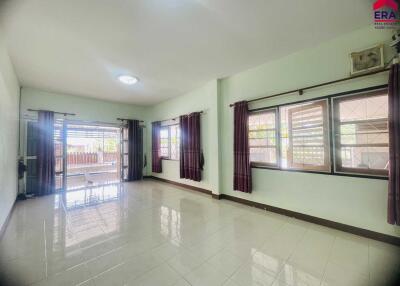 Spacious living room with large windows and tiled flooring