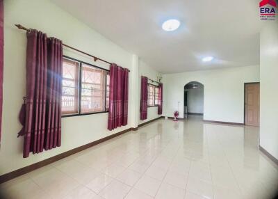 Spacious living room with large windows and tile flooring