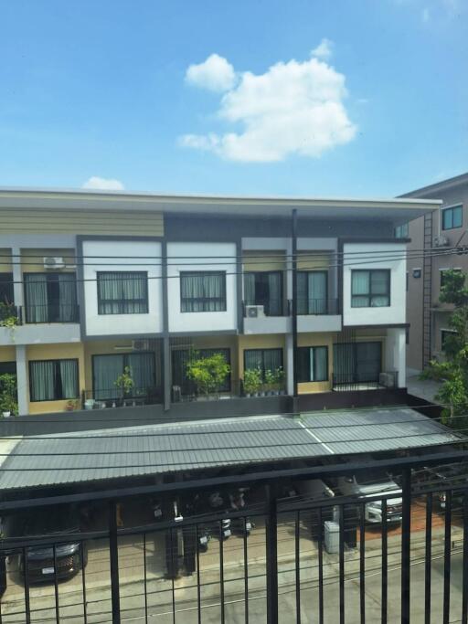 View of a residential building with balconies and a parking area