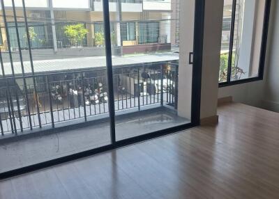 Spacious living room with large windows and a balcony view.