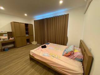 Spacious bedroom with wooden furniture and decor