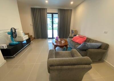 Modern living room with gray sofa, armchair, coffee table, and large glass doors