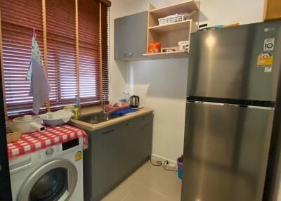 Modern kitchen with stainless steel refrigerator and washing machine