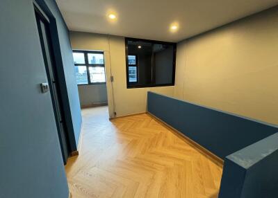 Well-lit hallway with wooden flooring and blue accent wall