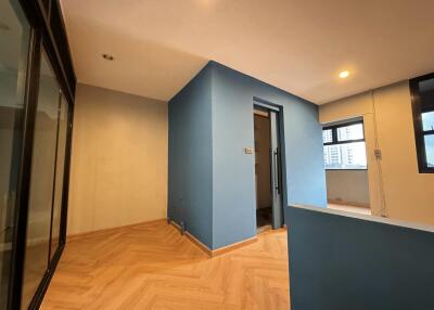 Interior view of a room with light wood flooring and blue walls