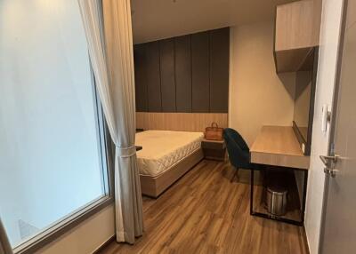 Modern bedroom with wooden flooring and workspace