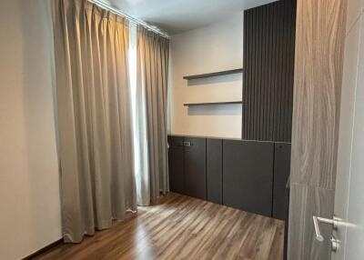 Empty bedroom with wooden flooring and curtains