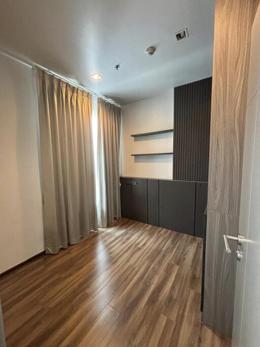 Empty bedroom with wooden flooring and curtains