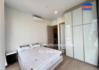 Spacious bedroom with bed, wardrobe, and air conditioner