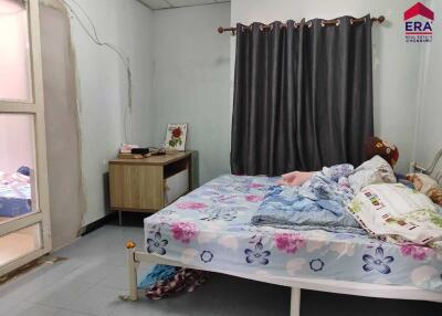 Bedroom with a double bed, side table, and a curtain over the window