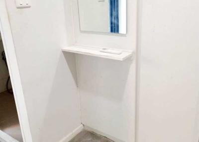 Small bathroom area with mirror and shelf