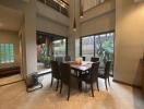 Modern dining area with large windows and high ceiling