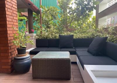 Outdoor patio with seating area and greenery