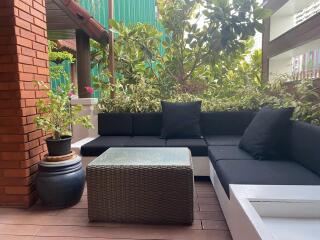 Outdoor patio with seating area and greenery