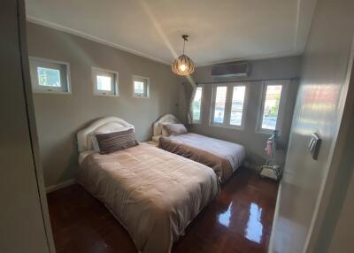 Bedroom with two beds, windows, and a hanging light fixture