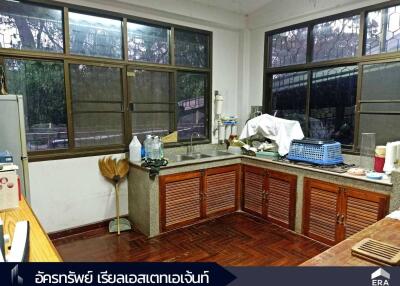 Modern kitchen with wooden cabinets, large windows, and granite countertops