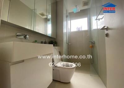 Modern bathroom with glass shower enclosure and large vanity mirror