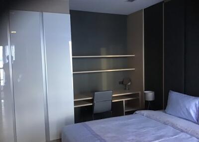 Modern bedroom with built-in wardrobe, desk, and bed