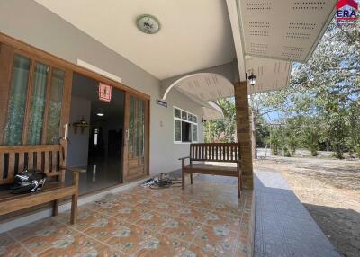 Front porch of a building with benches and a partial view of the interior