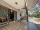 Front porch of a building with benches and a partial view of the interior